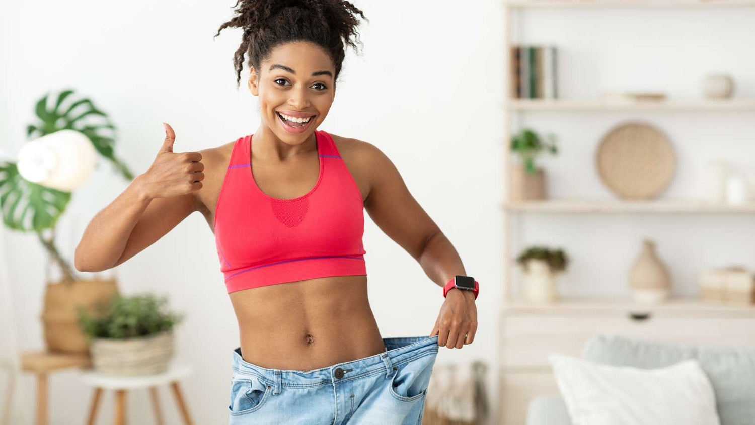 African Woman Showing Weight Loss Result Wearing Oversize Jeans Indoor