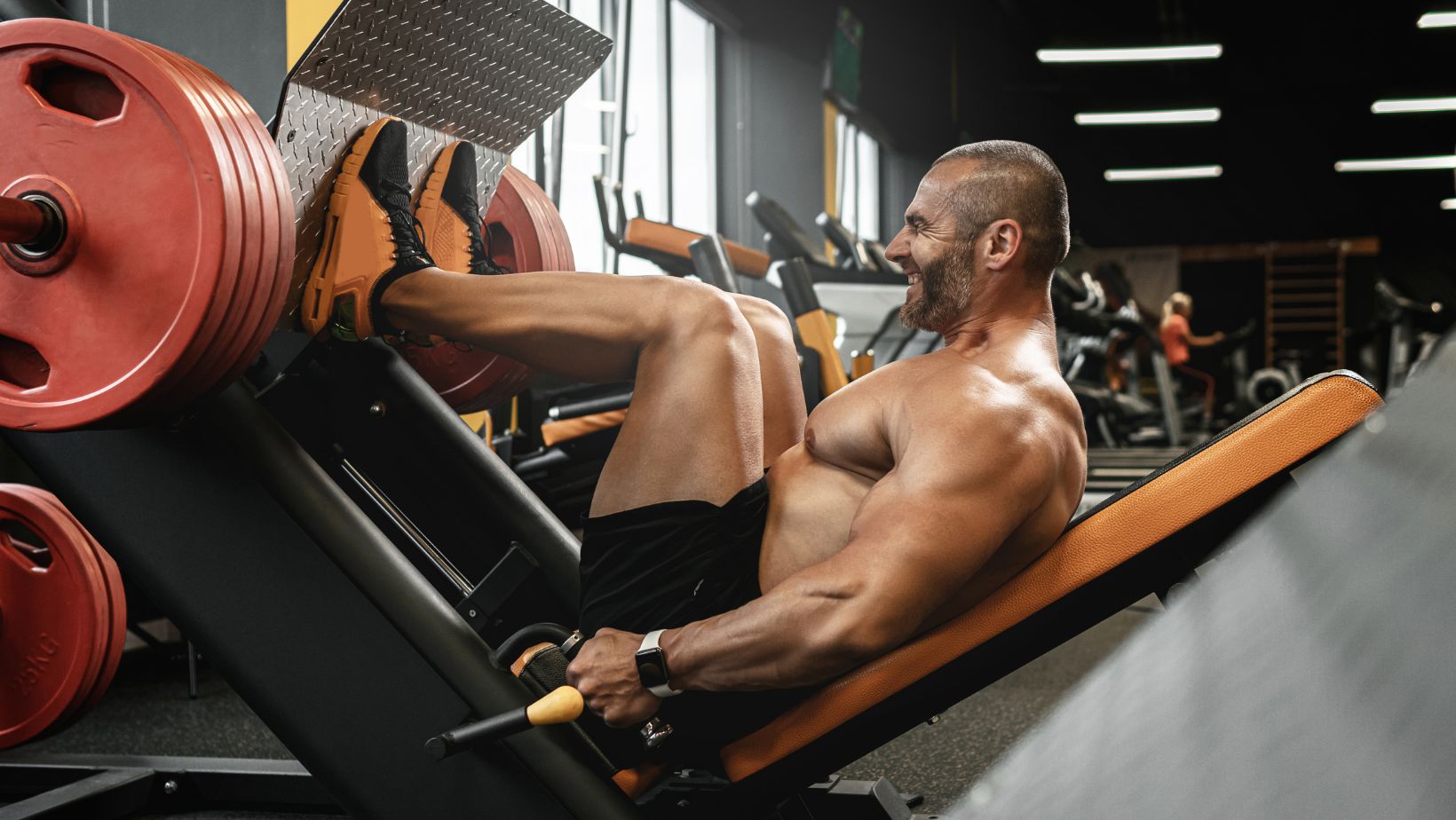 Bodybuilder Doing a Seated Leg Press Exercise in a Gym