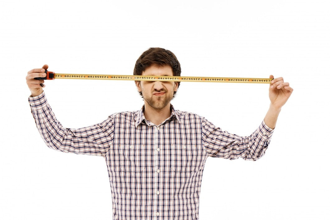 Funny man builder, open measuring tape over eyes