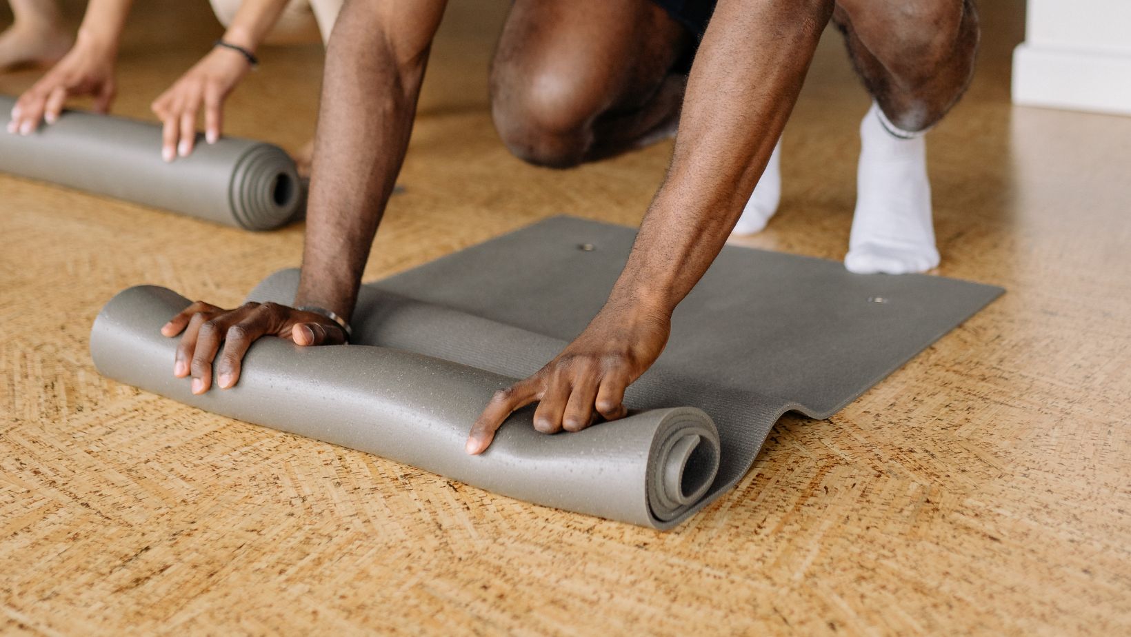 Man in White Shirt Holding Yoga Mat on the Floor