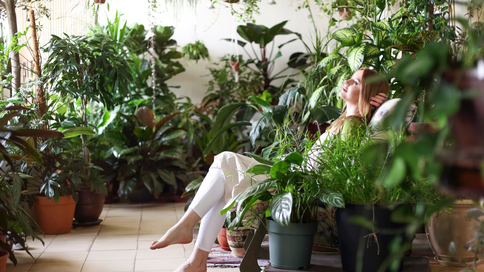 Relaxed Woman in Room with Green Plants