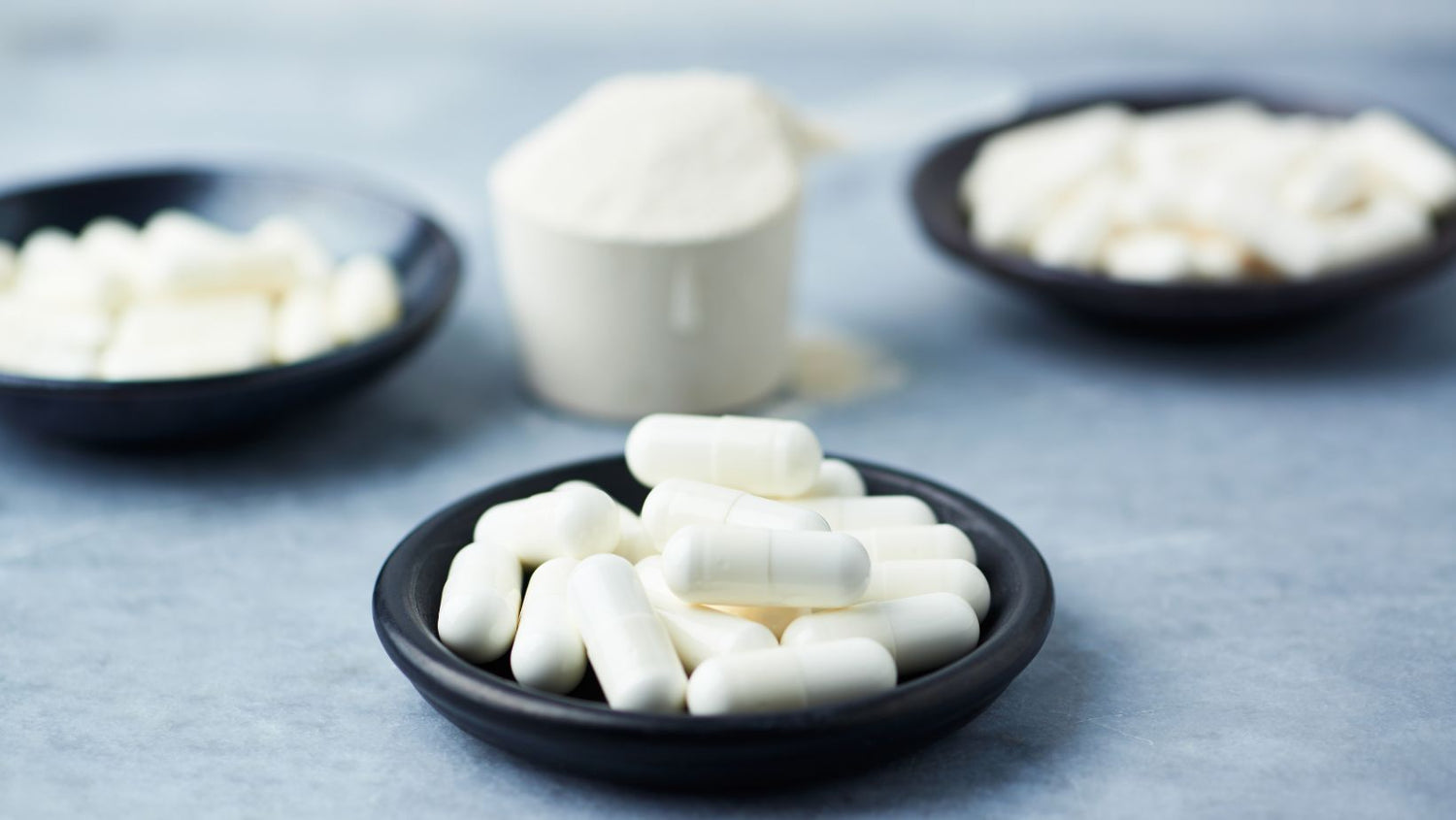 Scoop of creatine, and testosterone boosters in a small bowl