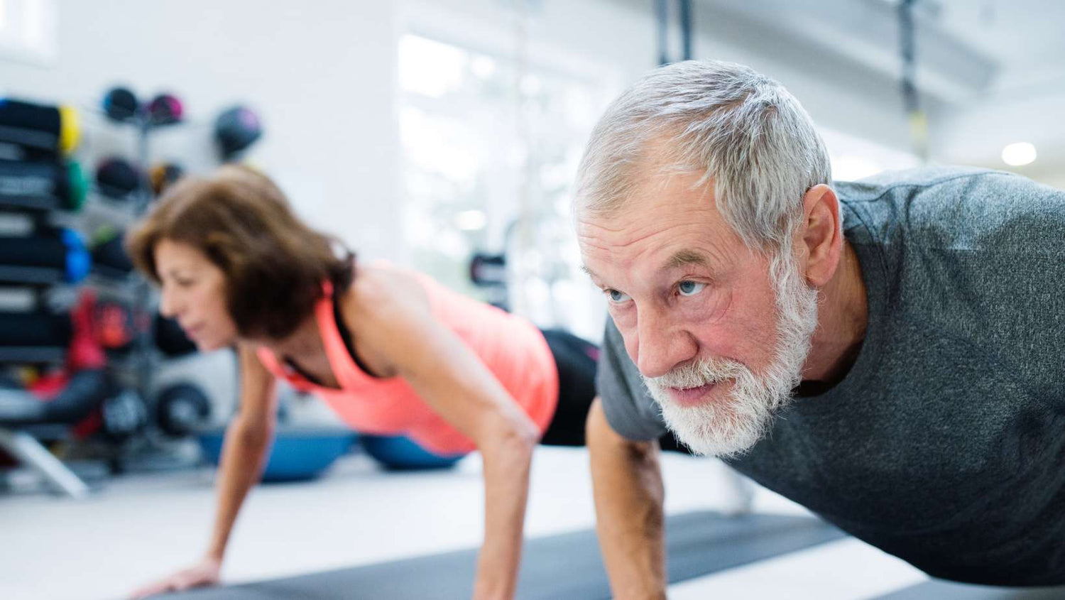 Senior Couple in Gym Working Out, Doing Push Ups