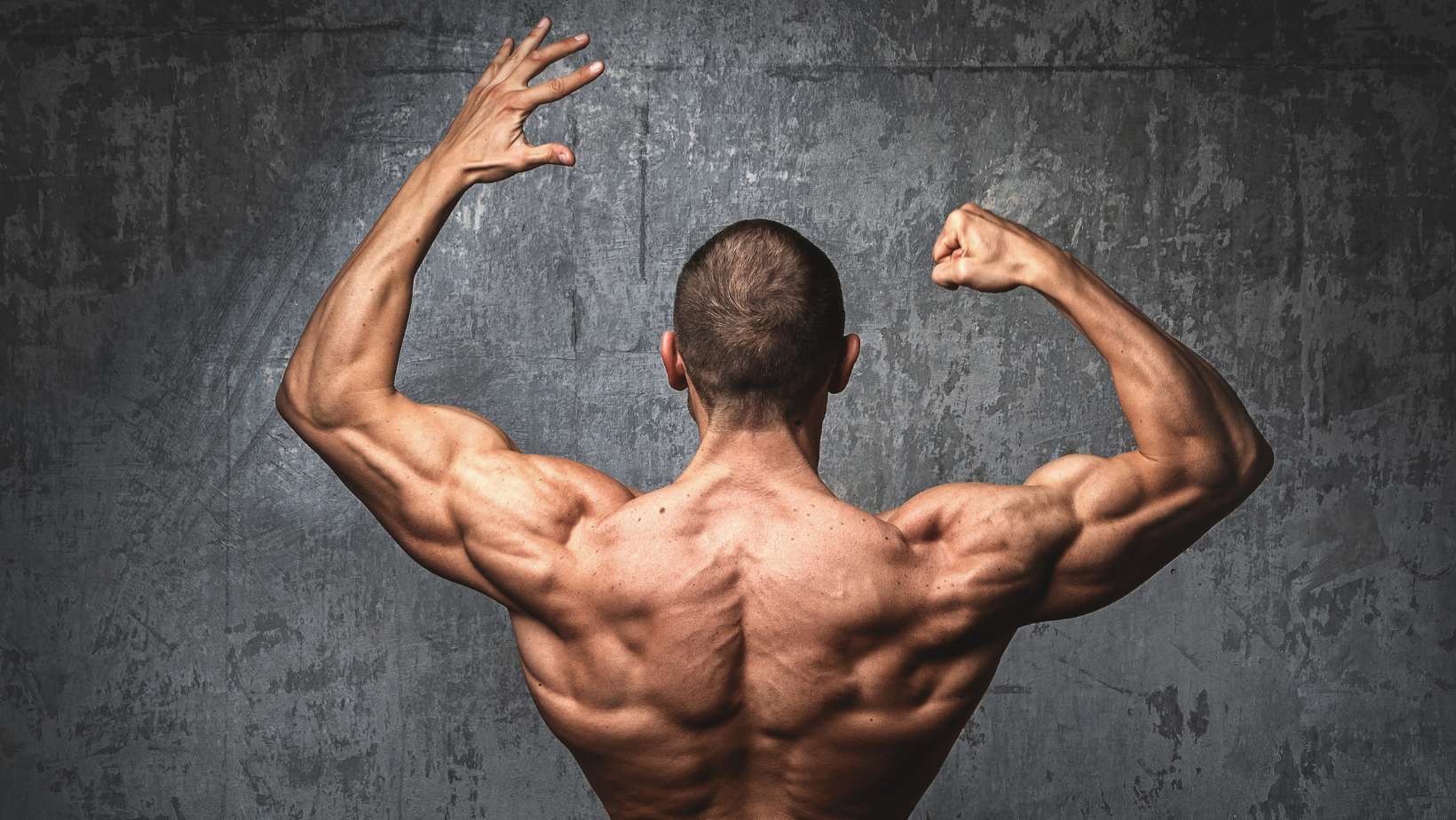 Sexy and muscular man posing against stone wall