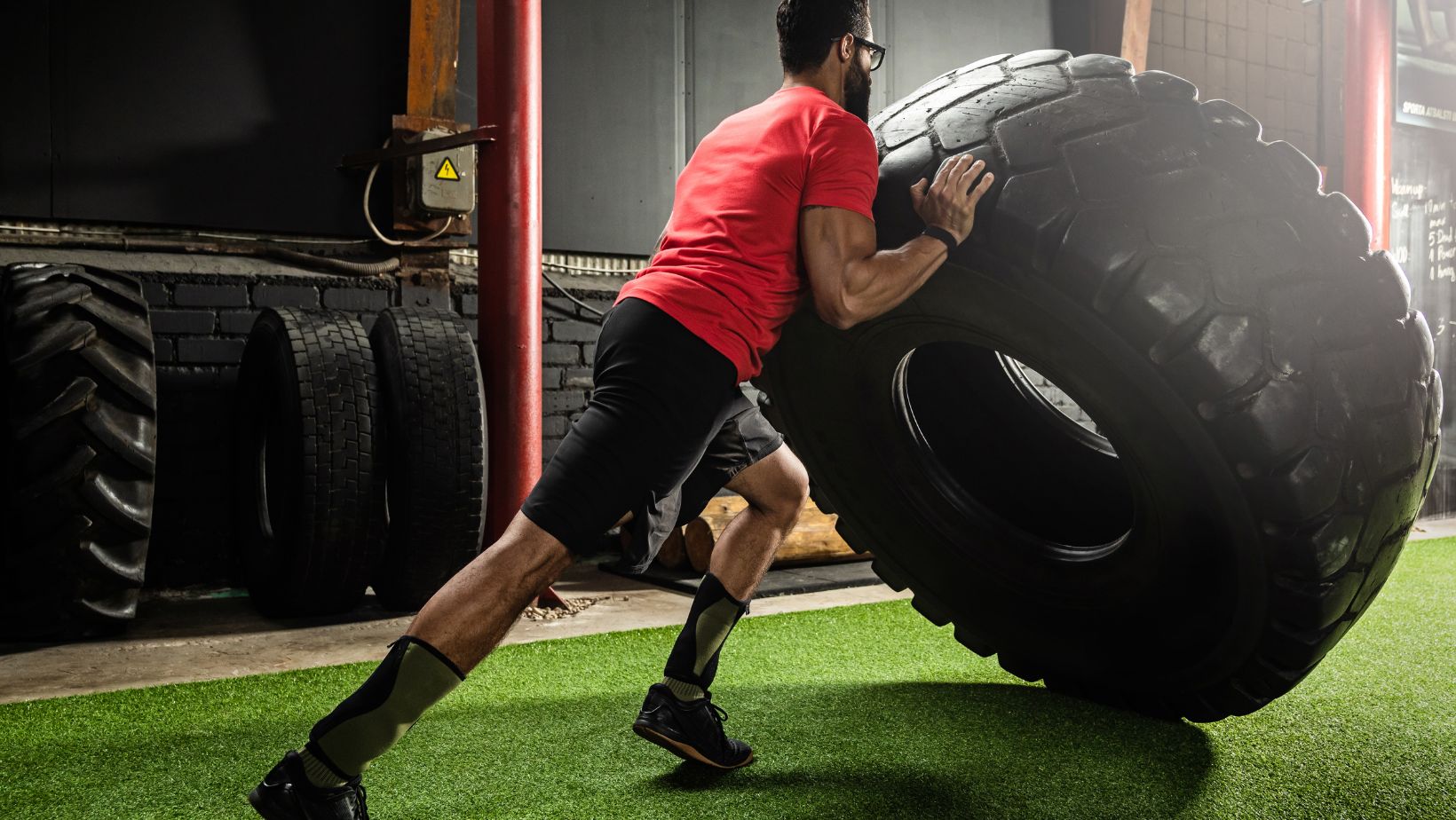 Strong Sportsman Doing a Tire Flip Exercise