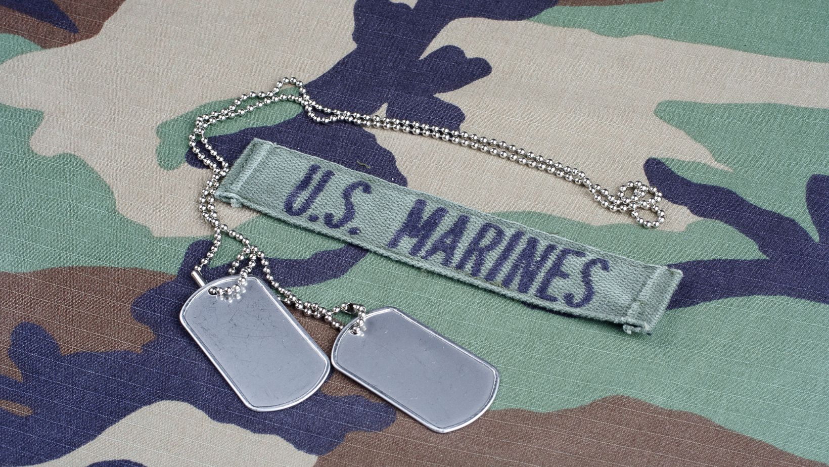 US MARINES branch tape and dog tags on woodland camouflage uniform