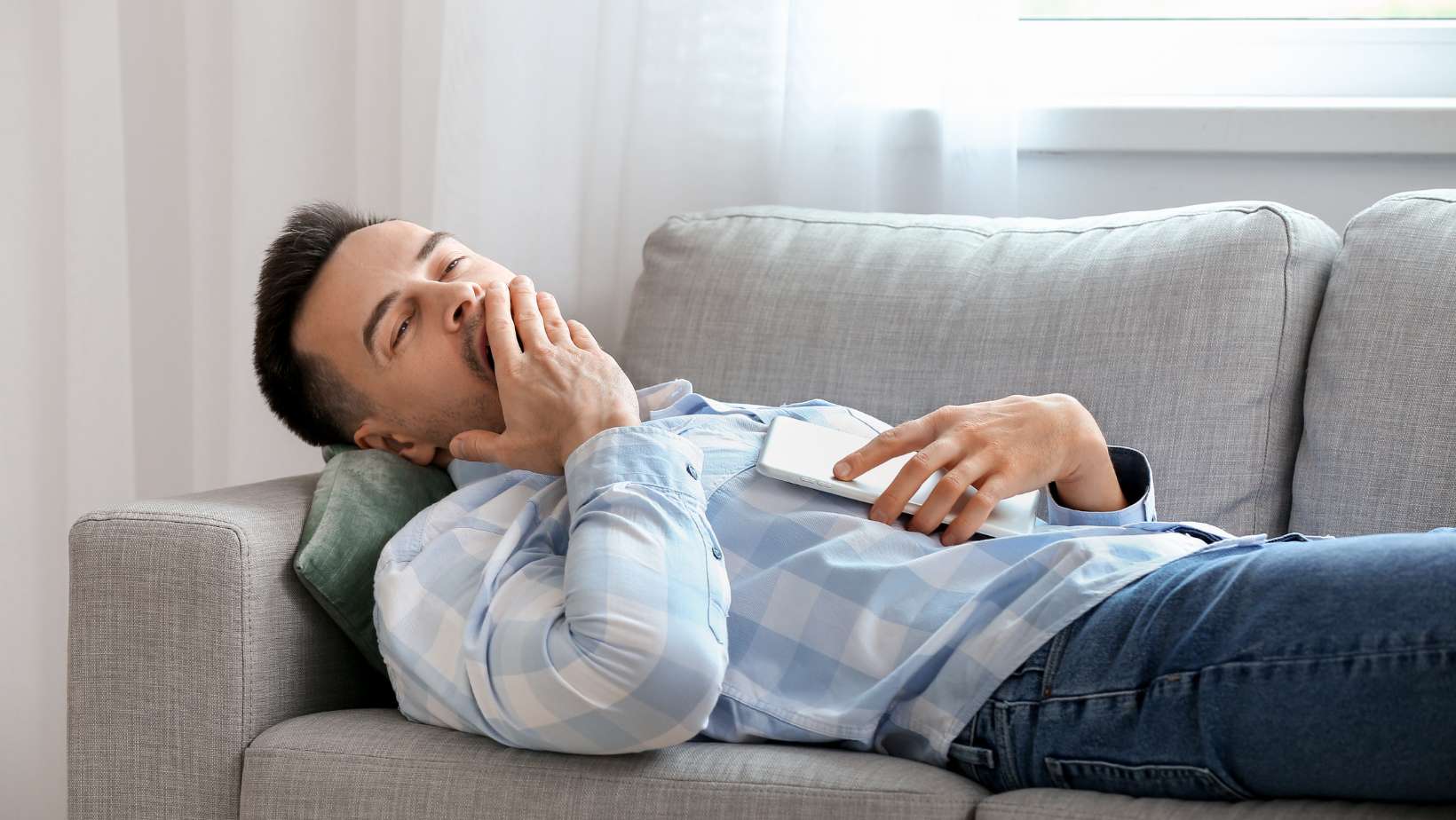 Young Man Suffering from Sleep Deprivation in the Couch