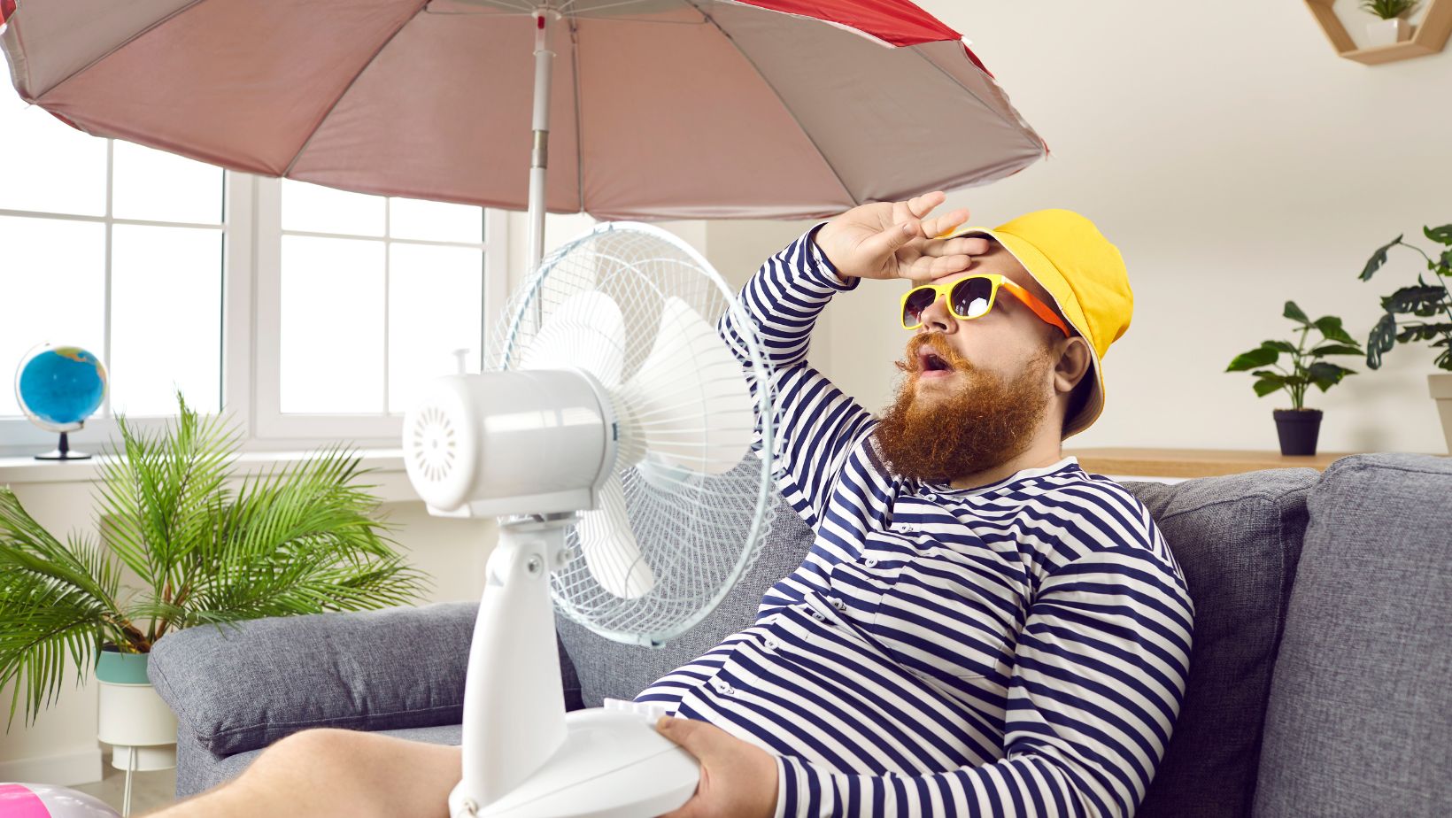 funny fat man sweating and using a fan to cool himself