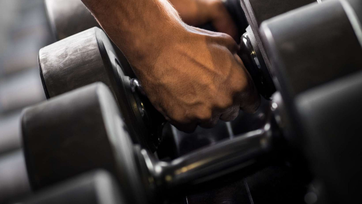 hand picking up dumbbell
